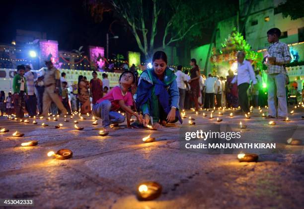 Hindu devotees light oil lamps at a temple for the Hindu God Shiva during the "Karthigai Deepam" in Bangalore on December 2, 2013. "Karthigai Deepam"...