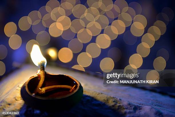 An oil lamp sits on the wall at a temple for the Hindu God Shiva during the "Karthigai Deepam" in Bangalore on December 2, 2013. "Karthigai Deepam"...