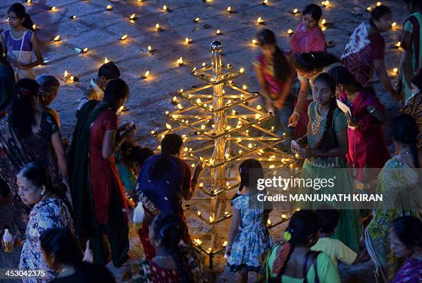 Hindu devotees light oil wick lamps at a temple for the Hindu God Shiva during the "Karthigai Deepam" in Bangalore on December 2, 2013. "Karthigai...