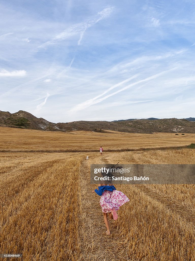 Girl running in wheat field