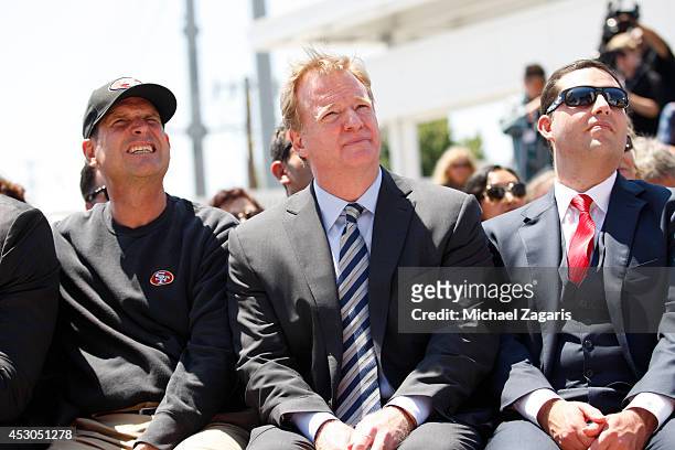 Head Coach Jim Harbaugh of the San Francisco 49ers sits with NFL Commissioner Roger Goodell and 49ers CEO Jed York during the the Ribbon Cutting...