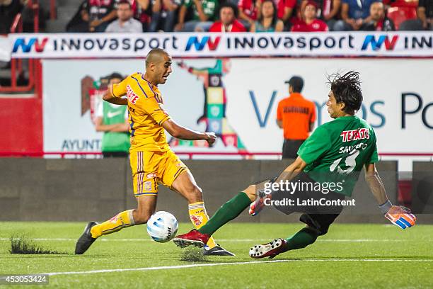 Guido Pizarro of Tigres faces Cirilo Saucedo and shoots on target during a match between Tijuana and Tigres UANL as part of 3rd round Apertura 2014...