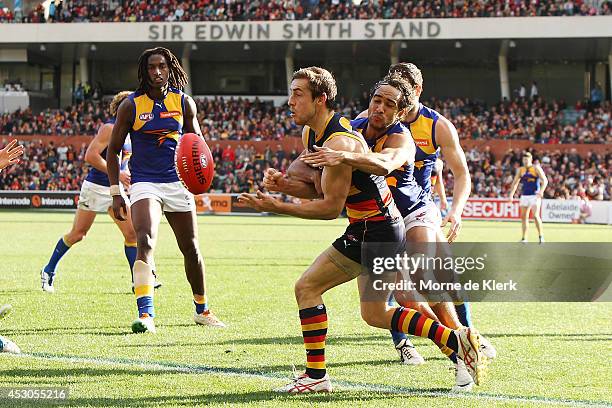 Richard Douglas of the Crows gets a pass away under pressure during the round 19 AFL match between the Adelaide Crows and the West Coast Eagles at...