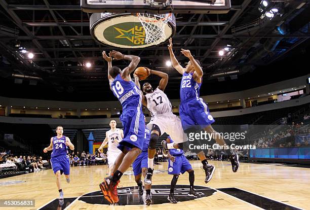 Jonathan Simmons of the Austin Toros shoots against Thanasis Antetokounmpo and Rodney Williams of the Delaware 87ers on December 1, 2013 at the Cedar...