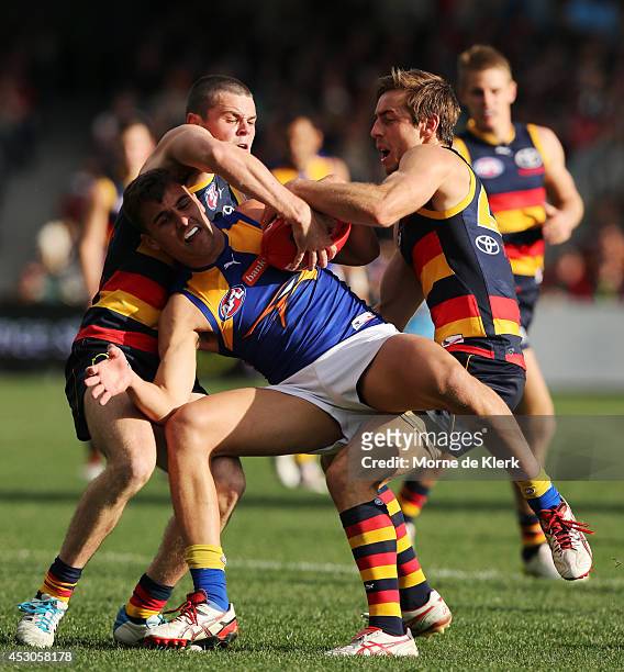Brad Crouch and Richard Douglas of the Crows tackles Dom Sheed of the Eagles during the round 19 AFL match between the Adelaide Crows and the West...