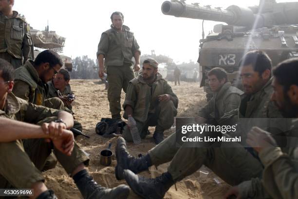 Israeli soldiers sit next to a tank in a deployment area on August 02, 2014 on Israel's border with the Gaza Strip. The Israeli military on Friday...