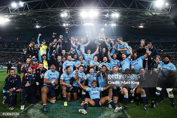 Waratahs players celebrate victory and hold the Super Rugby trophy during the Super Rugby Grand Final match between the Waratahs and the Crusaders at...