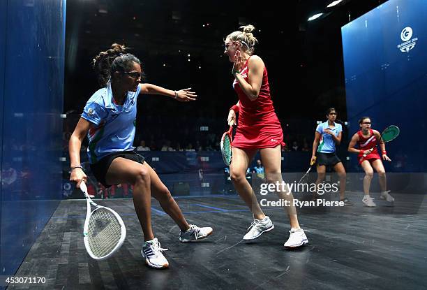 Dipika Pallikal of India is blocked by Laura Massaro of England during the Squash Women's Doubles Final between England and India at Scotstoun Sports...