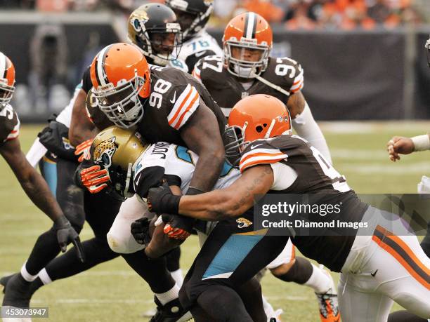 Defensive tackle Phil Taylor and defensive end John Hughes of the Cleveland Browns tackle running back Maurice Jones-Drew of the Jacksonville Jaguars...