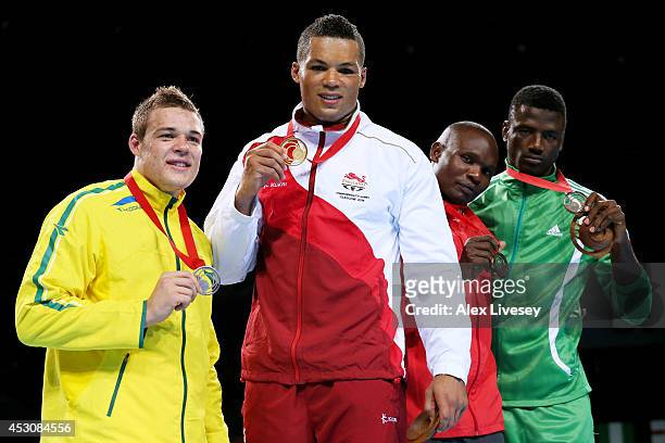 Gold medalist Joseph Joyce of England poses with silver medalist Joseph Goodall of Australia and bronze medalists Mike Sekabembe of Uganda and Efe...