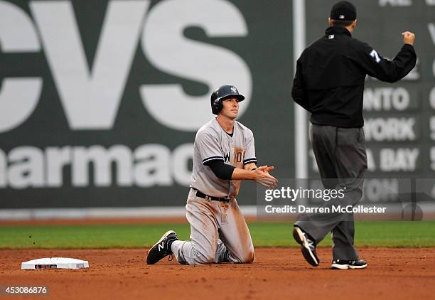 Stephen Drew of the New York Yankees is called out after making a base running error in the seventh inning against the Boston Red Sox at Fenway Park...