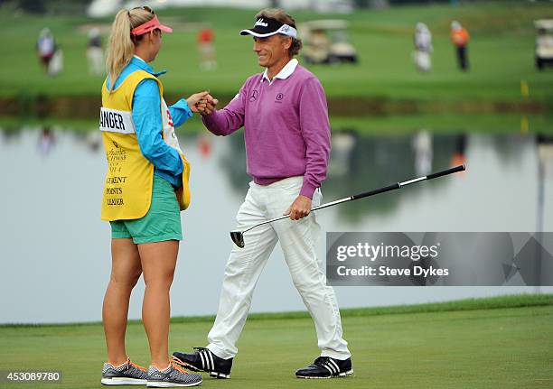 Christina Langer fist bumps her father, Bernhard Langer of Germany after he sank a birdie putt on the 18th hole during the second round of the 3M...