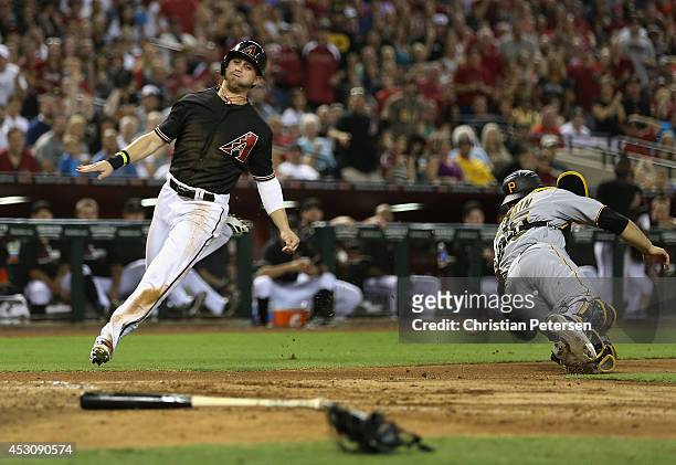 Ender Inciarte of the Arizona Diamondbacks slides in to score a run past catcher Russell Martin of the Pittsburgh Pirates during the fifth inning of...
