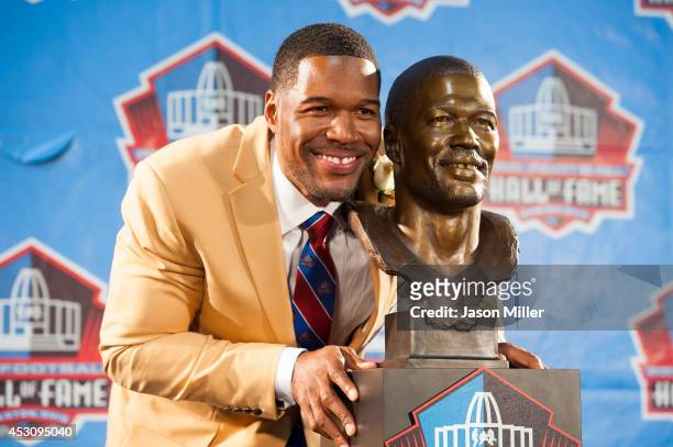 Former New York Giants defensive end Michael Strahan with his bust during the NFL Class of 2014 Pro Football Hall of Fame Enshrinement Ceremony at...