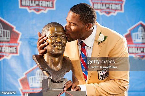 Former New York Giants defensive end Michael Strahan with his bust during the NFL Class of 2014 Pro Football Hall of Fame Enshrinement Ceremony at...