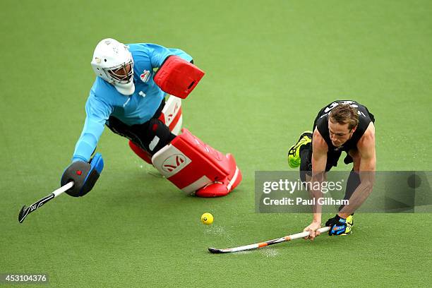 Hugo Inglis of New Zealand shoots past George Pinner of England to score in the shoot out in the bronze medal match between New Zealand and England...