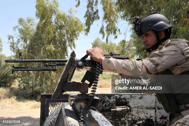Volunteer who joined the Iraqi army to fight against Jihadist militants of the Islamic State stands in a truck as he holds a position in Al-Othaym in...