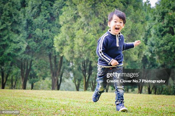 happy little boy running on the grass. - taiwanesischer abstammung stock-fotos und bilder