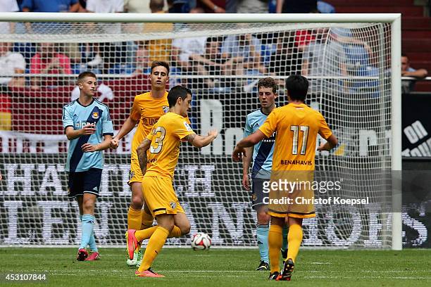 Roberto Chen of Malaga celebrates the first goal and Reece Burke and Daniel Whitehead of West Ham United look dejected during the match between FC...