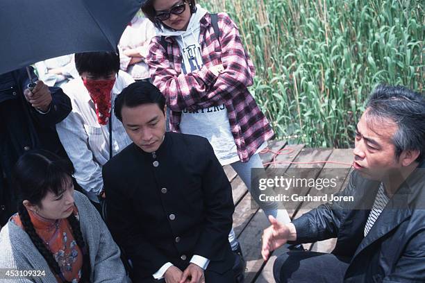 Chinese movie actress Gong Li with Hong Kong actor Leslie Cheung Kwok Wing, with director Chen Kaige, during the filming of 'Temptress Moon'.