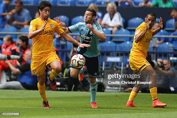 Pablo Perez of Malaga and Jose Rosales of Malaga challenge Mauro Zarate of Malaga during the match between FC Malaga and West Ham United as part of...