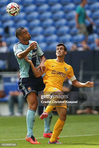 Winston Reid of West Ham United and Juanmi of Malaga go up for a header during the match between FC Malaga and West Ham United as part of the Schalke...