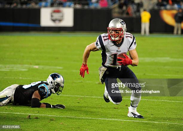 Julian Edelman of the New England Patriots runs with a catch against Melvin White of the Carolina Panthers at Bank of America Stadium on November 18,...