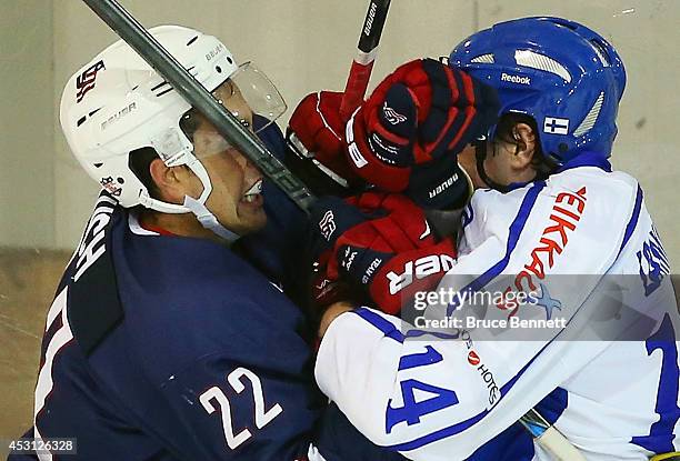 Alex Tuch of USA Blue and Juho Lammikko of Team Finland get their gloves up during the third period in the 2014 USA Hockey Junior Evaluation Camp at...