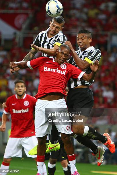 Fabricio of Internacional battles for the ball against David Braz and Alisson of Santos during match between Internacional and Santos as part of...