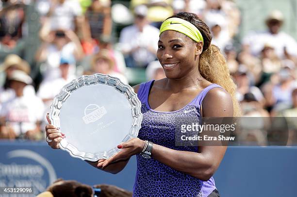 Serena Williams of the USA holds up the trophy after beating Angelique Kerber of Germany in the finals of the Bank of the West Classic at the Taube...