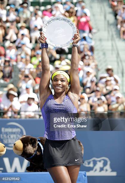 Serena Williams of the USA holds up the trophy after beating Angelique Kerber of Germany in the finals of the Bank of the West Classic at the Taube...