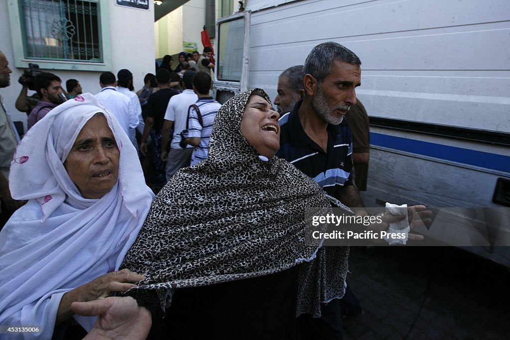 Relatives mourn during the funeral of at least 9 members of...