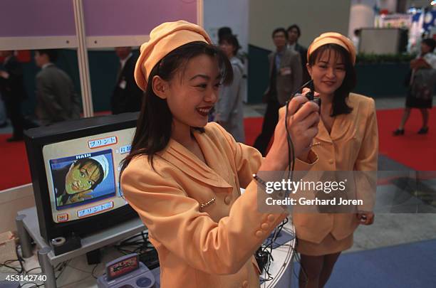 Young women pose at a booth at the Tokyo Toy Fair held at the Tokyo International Exhibition Centre.