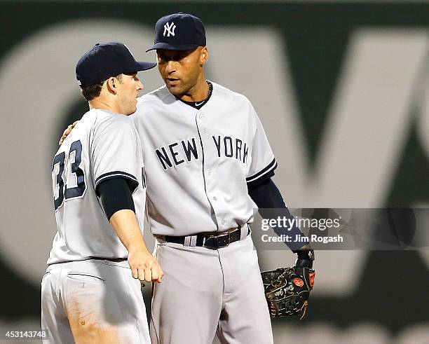 Derek Jeter of the New York Yankees celebrates with Stephen Drew after defeating the Boston Red Sox 8-7at Fenway Park on August 3, 2014 in Boston,...