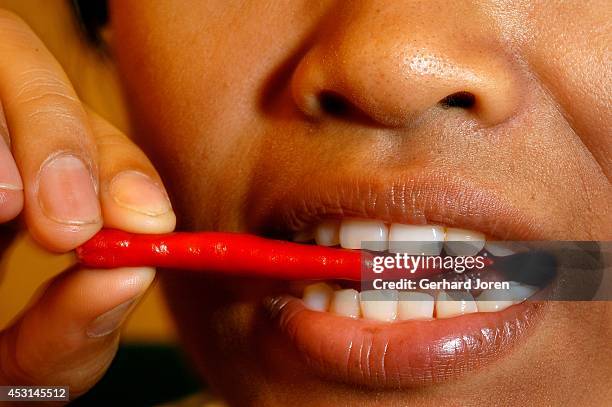 Woman eating red chili.