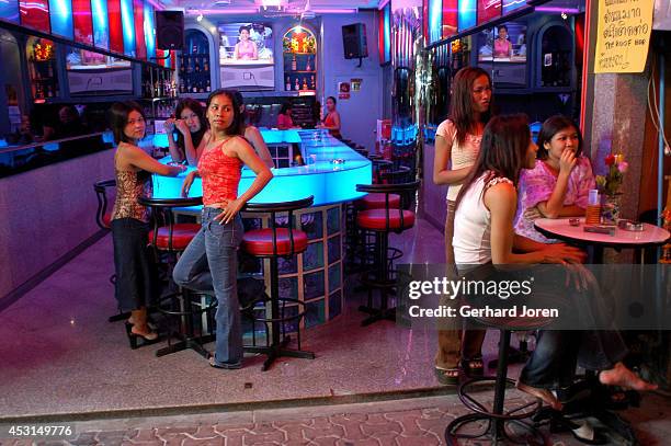 Girls waiting for customers in an almost empty bar on Walking Street. Pattaya is a sea-side resort city a couple of hours east of Bangkok that is...
