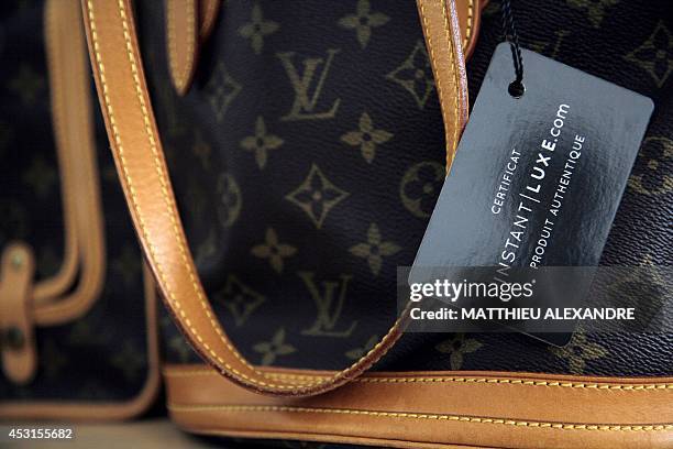 This photo shows a pre-owned luxury bag labelled after expertise at Instant Luxe office on July 30, 2014 in Paris. Instant Luxe buys and sells...