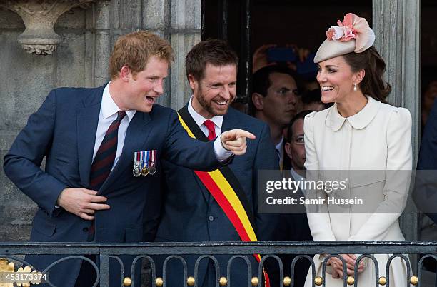 Prince Harry makes a joke as Catherine, Duchess of Cambridge looks on from the balcony of the town hall as they attend a reception at the Grand Place...