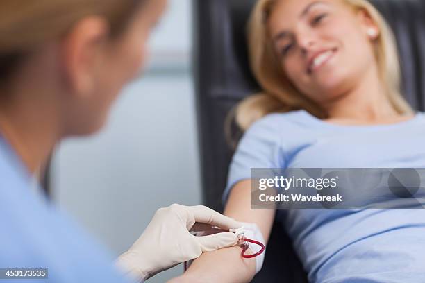 nurse getting blood from on a female donor - blood drive stock pictures, royalty-free photos & images