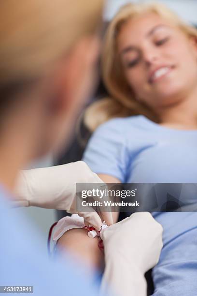 nurse practicing a transfusion on her female patient - blood bag stock pictures, royalty-free photos & images