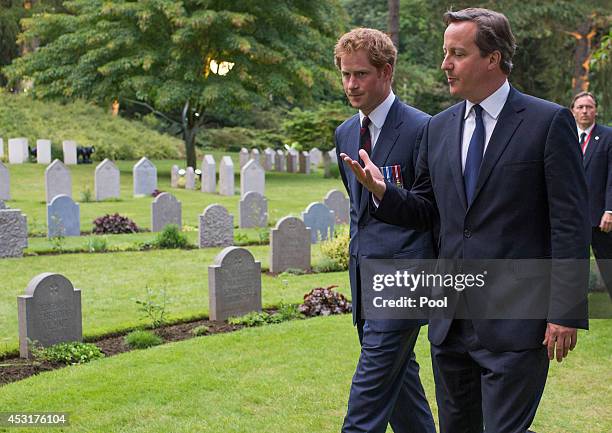 Prince Harry walks with Prime Minister David Cameron past war graves at St Symphorien Military Cemetery on August 4, 2014 in Mons, Belgium. Monday...