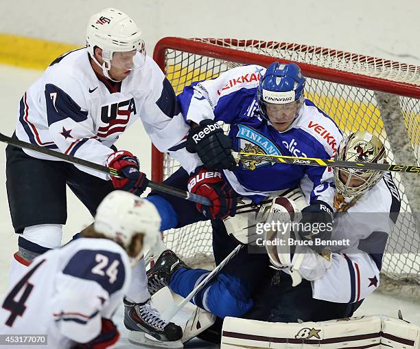 Teemu Turunen of Team Finland goes in on Thatcher Demko and JT Compher of USA White during the 2014 USA Hockey Junior Evaluation Campat Lake Placid...