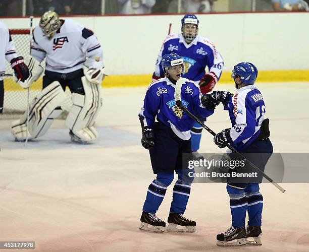 Janne Puhakka of Team Finland congratulates Saku Kinnunen on his second period goal against USA White during the 2014 USA Hockey Junior Evaluation...