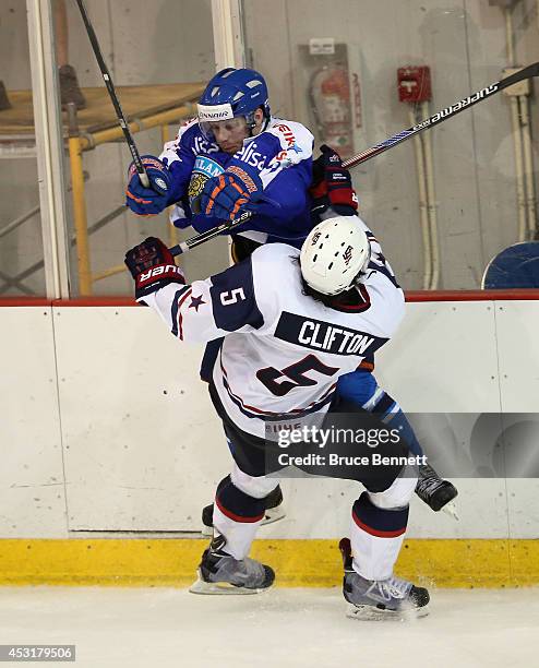 Connor Clifton of USA White is hit by Otto Rauhala of Team Finland during the 2014 USA Hockey Junior Evaluation Camp at the Lake Placid Olympic...