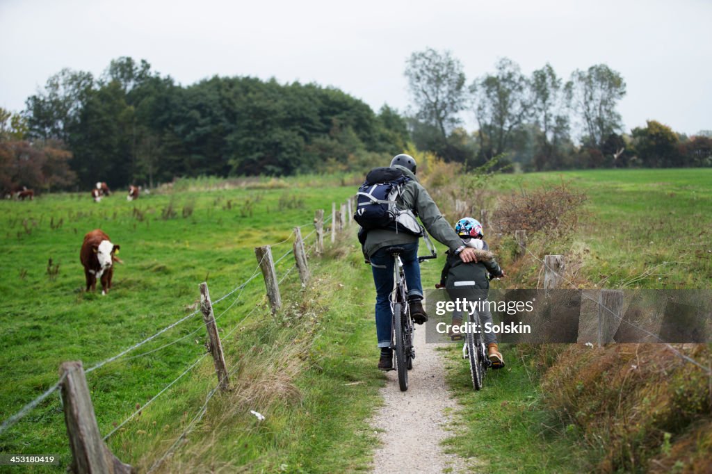 Father and son cycling together in nature