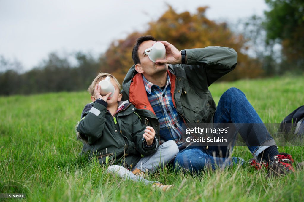 Father and son having hot drink together