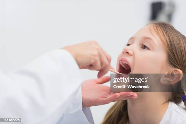 general practitioner auscultating the throat of a patient - throat exam stock pictures, royalty-free photos & images