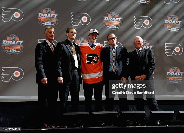 Travis Sanheim stands with team personnel after being selected 17th overall by the Philadelphia Flyers during the 2014 NHL Entry Draft at Wells Fargo...