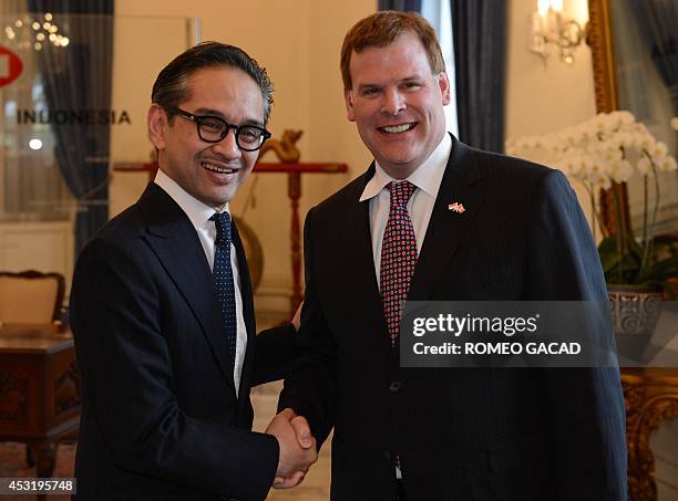 Indonesian Foreign Minister Marty Natalegawa shakes hands with his Canadian counterpart John Baird before their bilateral meeting in Jakarta on...