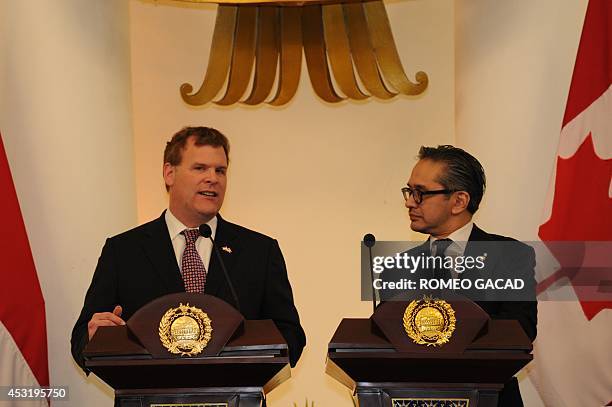 Canadian Foreign Minister John Baird delivers his statement while his Indonesian counterpart Marty Natalegawa listens after their bilateral meeting...